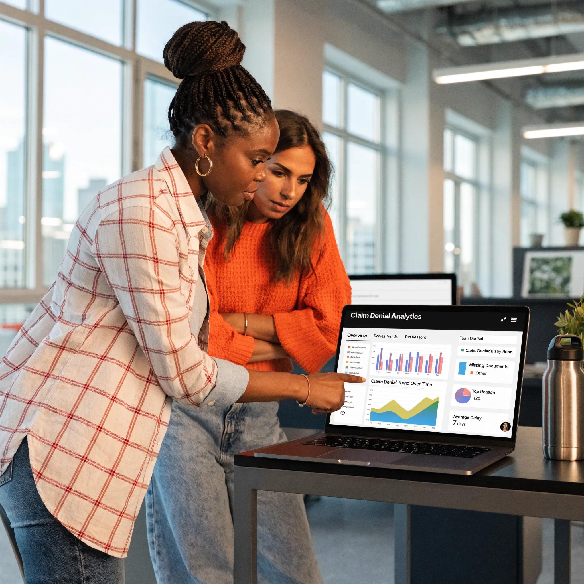 A healthcare worker analyzing denial trends via an analytics dashboard during a collaborative meeting